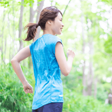 新緑の中でジョギングをする女性