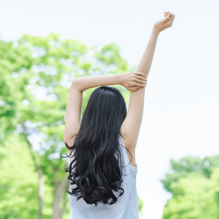 新緑の中でストレッチをする女性