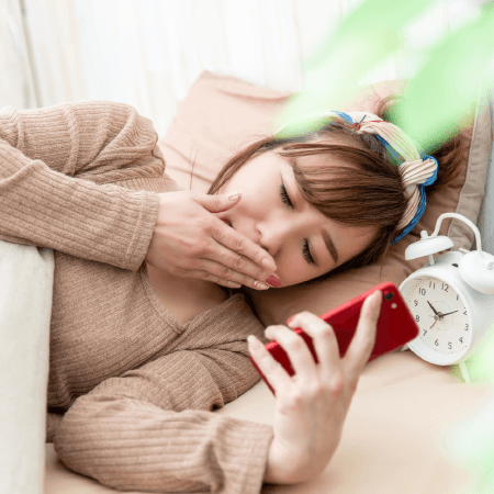 夜更かししてスマホを操作する女性