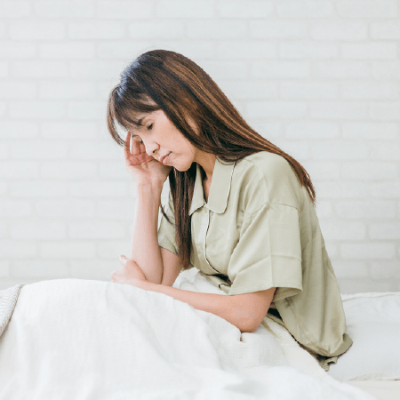 ベッドで悩む中年の女性