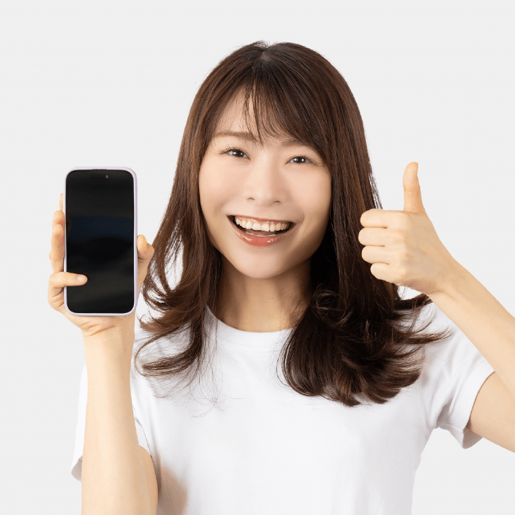 スマホを片手にグッドポーズをする笑顔の女性